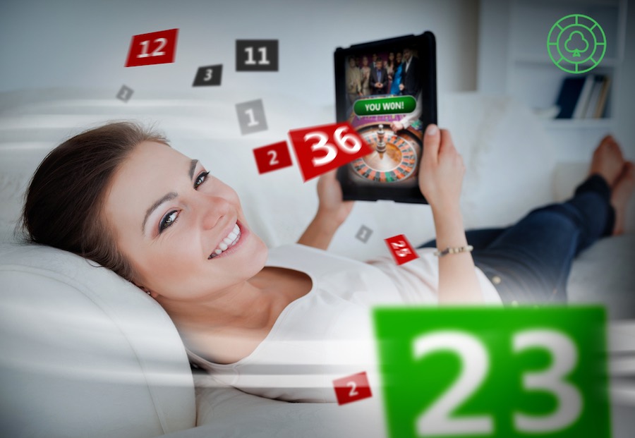 Žena leži na kauču i kocka na tabletu s holografskim brojevima oko sebe